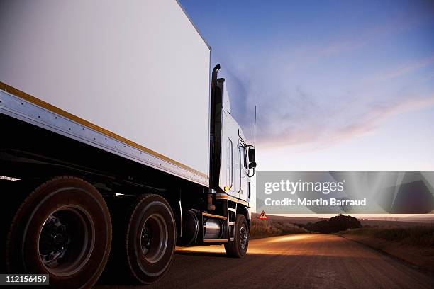 semi-truck driving on dirt road - trucking stock pictures, royalty-free photos & images