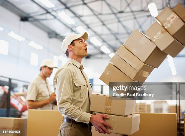 worker dropping boxes in shipping area - postbode stockfoto's en -beelden