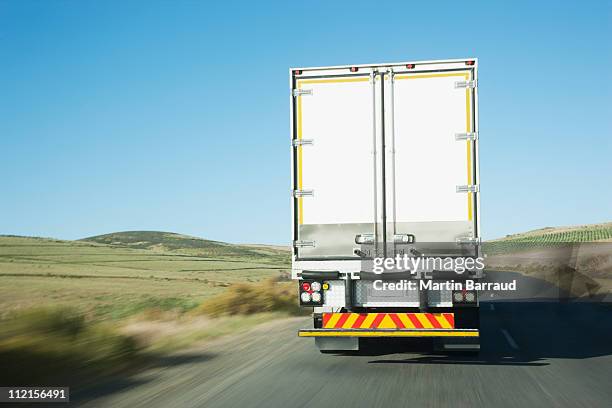 semi-truck driving on remote rode - back of truck stock pictures, royalty-free photos & images
