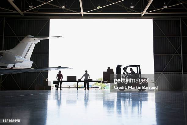 trabalhadores, caixas e empilhadeira no hangar - aircraft - fotografias e filmes do acervo