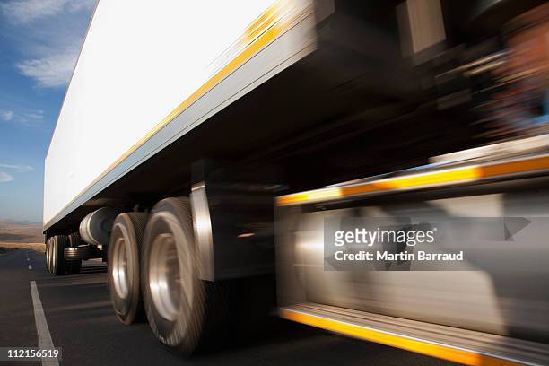 semi-truck speeding on remote road - wiel stockfoto's en -beelden