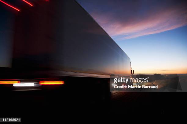 semi-truck speeding on remote road - lange sluitertijd stockfoto's en -beelden