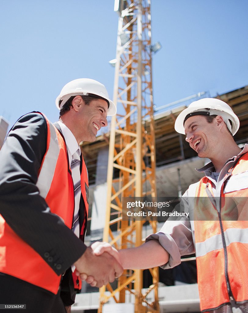 Construction worker shaking hands on construction site