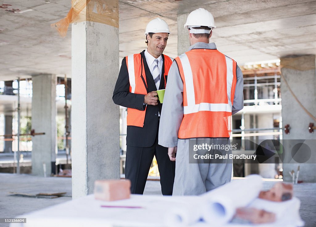 Businessman talking to construction worker on construction site