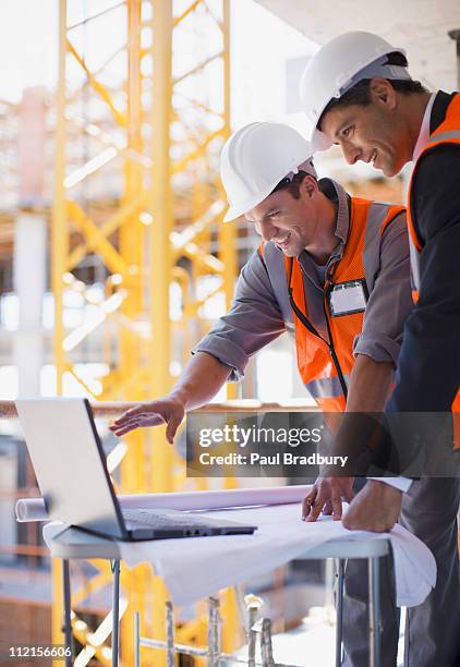 construction workers using laptop on construction site - business vertical stock pictures, royalty-free photos & images