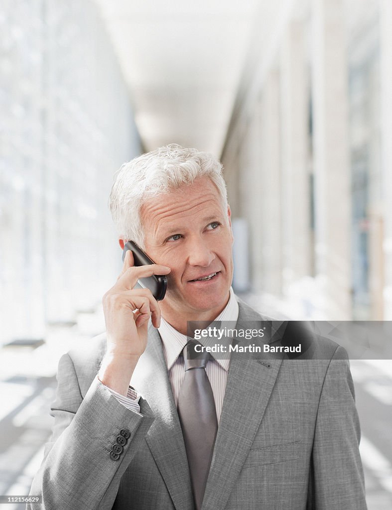 Businessman talking on cell phone in office