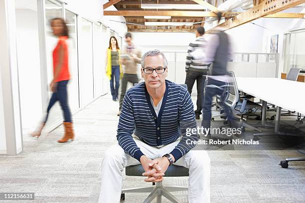 businessman sitting in busy office - office action foto e immagini stock