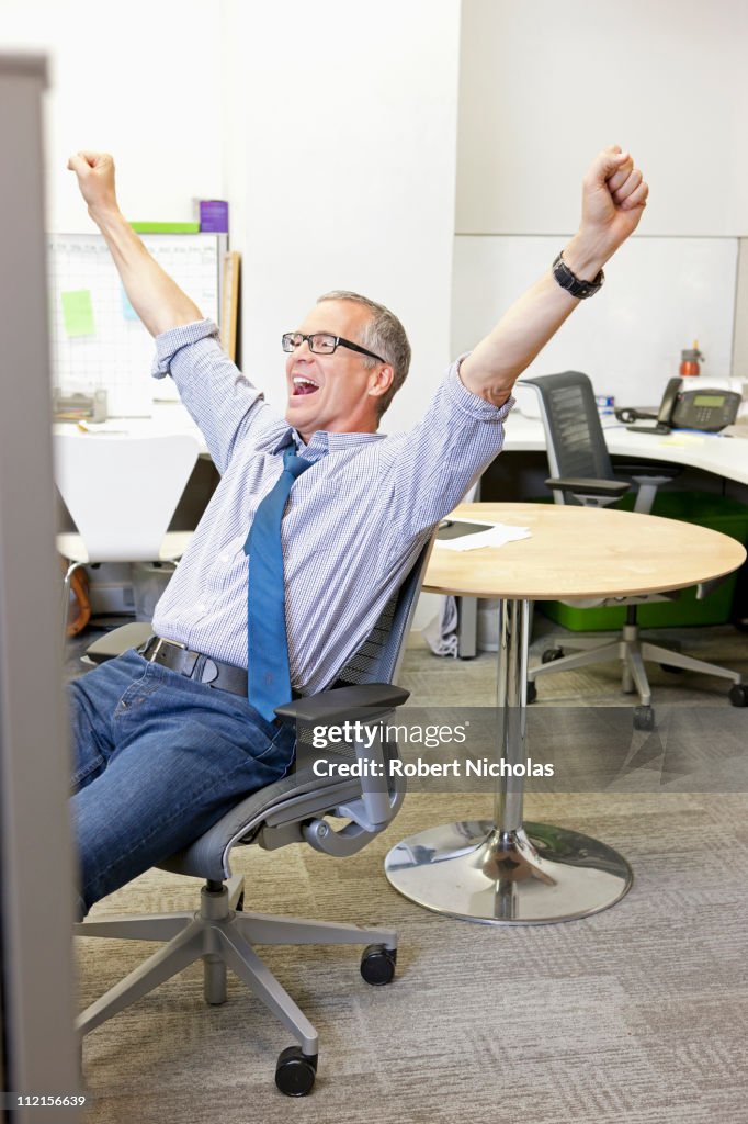 Businessman cheering in office