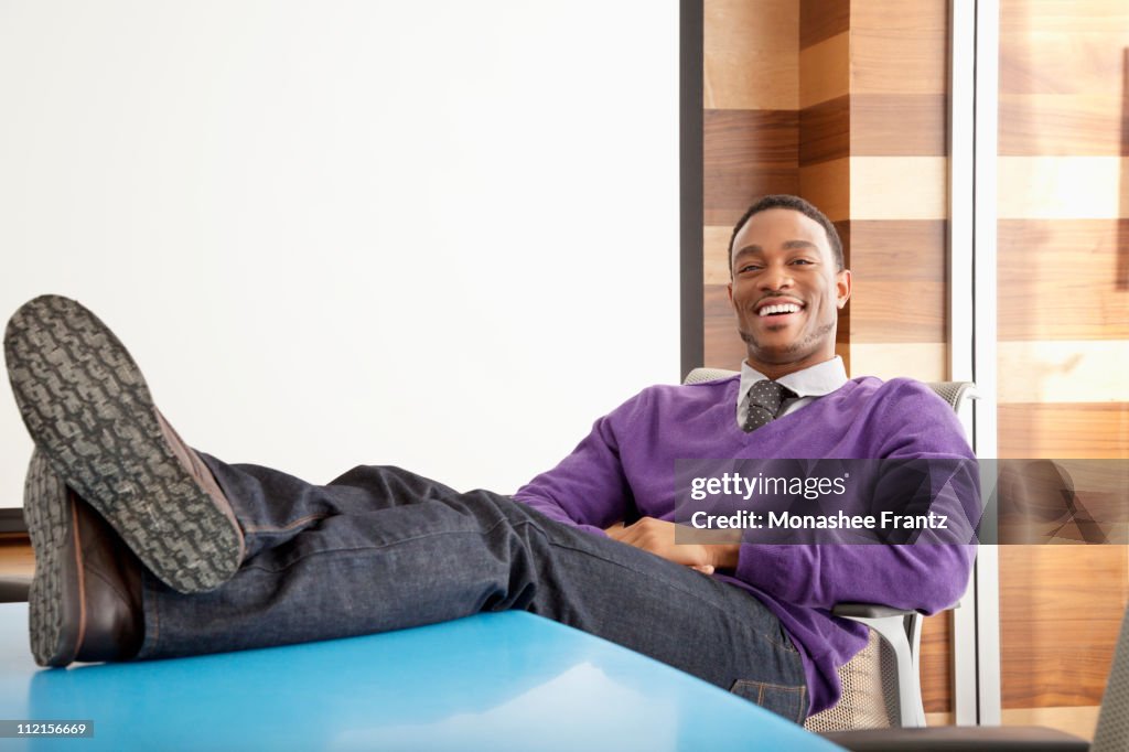 Businessman sitting in office with feet up