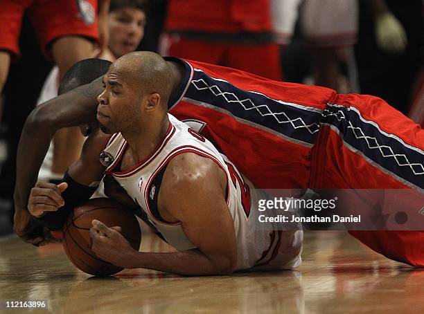 Taj Gibson of the Chicago Bulls battles for a loose ball with Johan Petro of the New Jersey Nets at the United Center on April 13, 2011 in Chicago,...