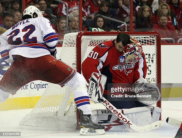 Goaltender Michal Neuvirth of the Washington Capitals loses his mask in his game against Brian Boyle and the New York Rangers in Game One of the...