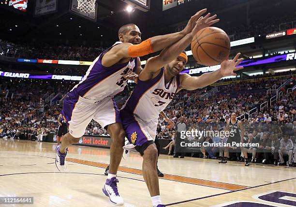 Grant Hill and Jared Dudley of the Phoenix Suns reach for a loose ball during the NBA game against the San Antonio Spurs at US Airways Center on...
