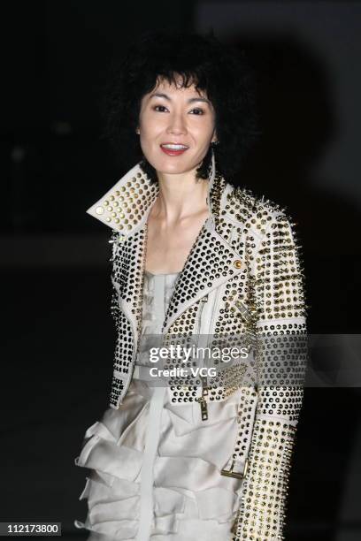 Maggie Cheung poses for photos as she arrives at the corporate event of the fashion apparel company Burberry at Sparkle Roll Plaza on April 13, 2011...