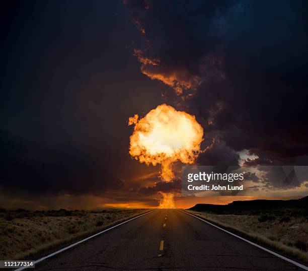 fireball exploding over a long road. - fireball stock-fotos und bilder