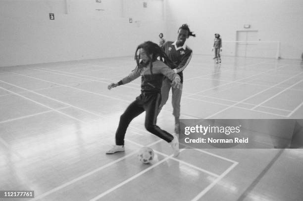 Jamaican singer-songwriter Bob Marley being challenged by Jamaican musician Trevor Bow, during a football match between a team led by Marley and...