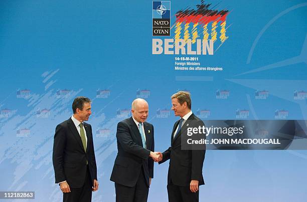 Britain's Foreign Secretary William Hague is greeted by NATO Secretary General Anders Fogh Rasmussen and German Foreign Minister Guido Westerwelle at...