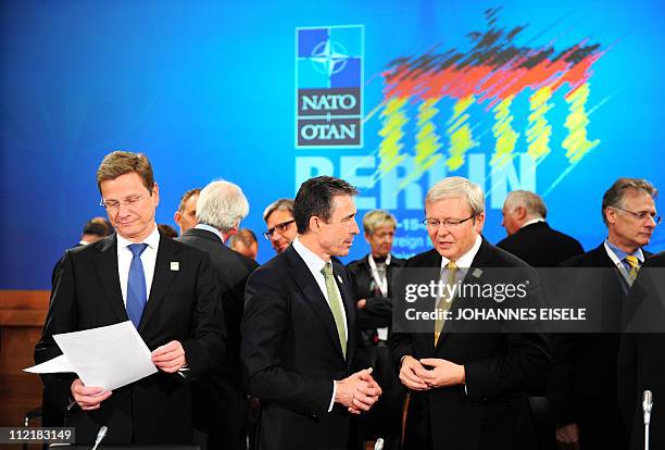 German Foreign Minister Guido Westerwelle reads some documents as NATO Secretary General Anders Fogh Rasmussen talks with Australian Foreign Minister...