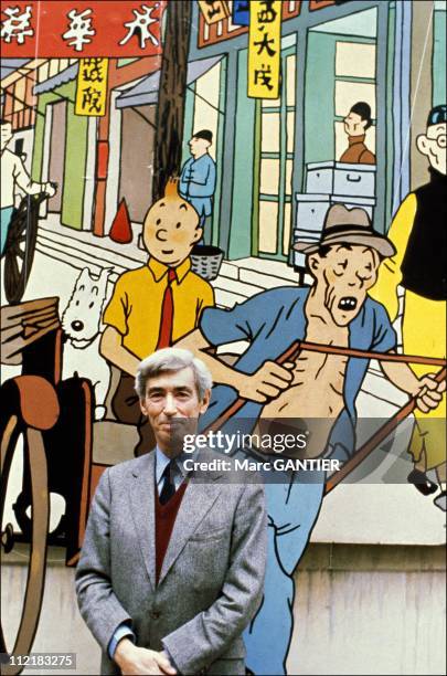 Herge poses for a portrait in front of a picture of his comic creation "Tintin" in Brussels,Belgium.