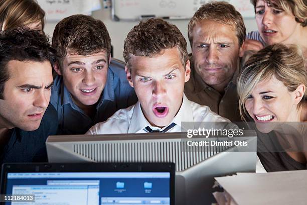 group of people looking shocked at computer screen - person with in front of screen stockfoto's en -beelden