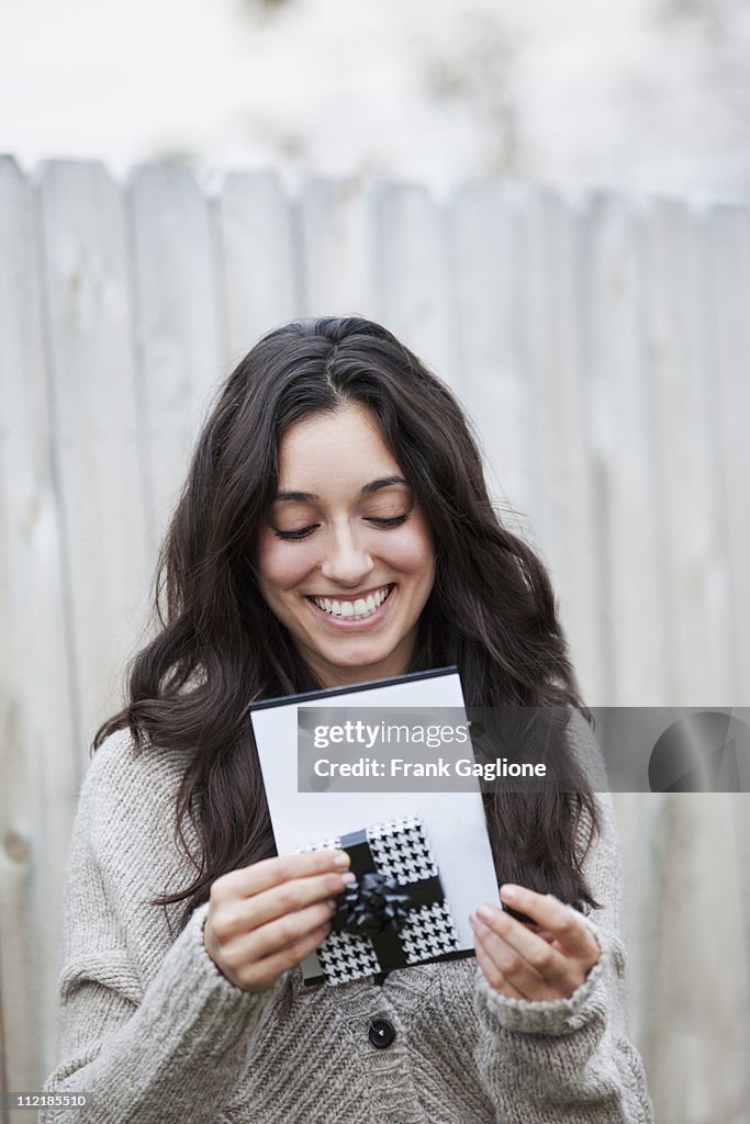 Young Woman Opening a Card and Gift.