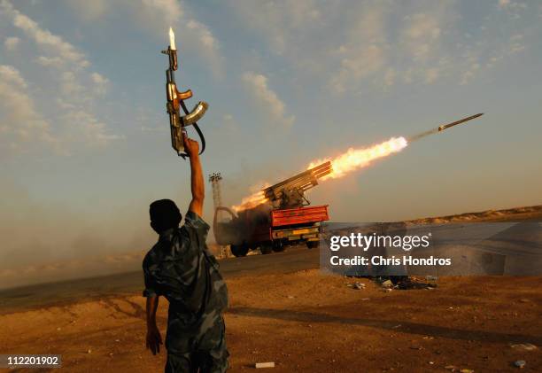 Rebel fighter celebrates as his comrades fire a rocket barrage toward the positions of troops loyal to Libyan ruler Muammar Gaddafi April 14, 2011...