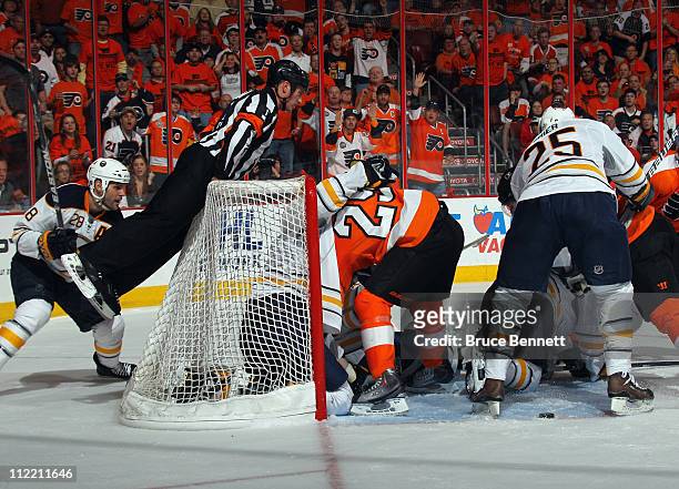 Referee Kelly Sutherland climbs on the back of the net to get a better view of the play between the Philadelphia Flyers and the Buffalo Sabres in...