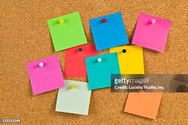 pieces of note paper on a cork bulletin board - puntina da disegno foto e immagini stock