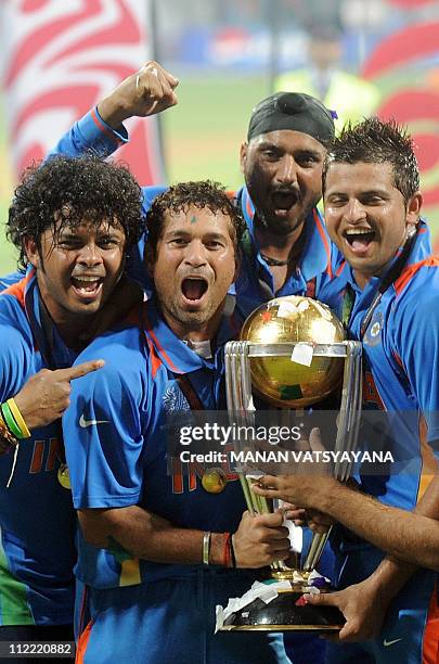 Indian cricketer Sachin Tendulkar celebrates with teammates as he holds the trophy after beating Sri Lanka in the ICC Cricket World Cup 2011 final...
