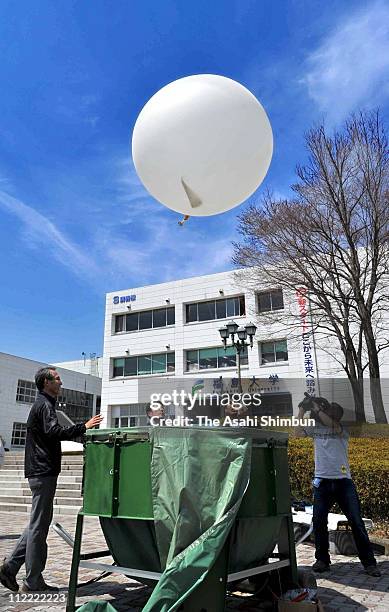 Fukushima University students release the balloon of the radiosonde, to measure the radoactive substances at Fukushima University on April 15, 2011...