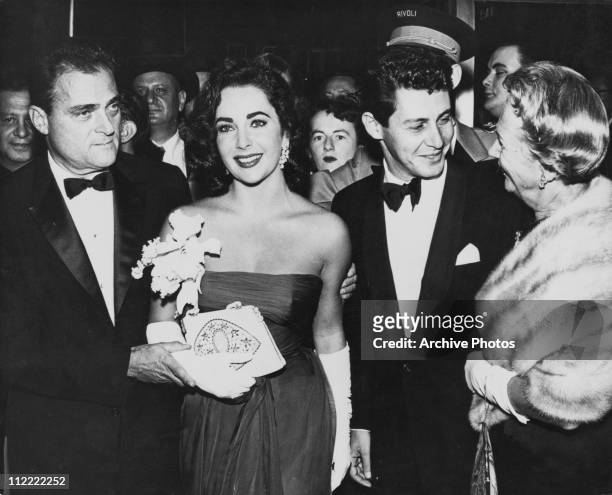 Actress Elizabeth Taylor at an event with her husband film producer Mike Todd , and singer Eddie Fisher, circa 1957.