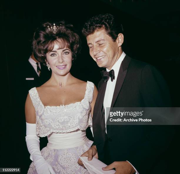 American singer and actor Eddie Fisher and British actor Elizabeth Taylor attend the Academy Awards, Los Angeles, California, circa 1960.