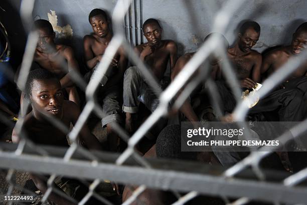 Men arrested by pro-Ouattara armed militia and suspected of looting wait in jail in a district of Abidjan on April 15, 2011. Ivory Coast's slow...