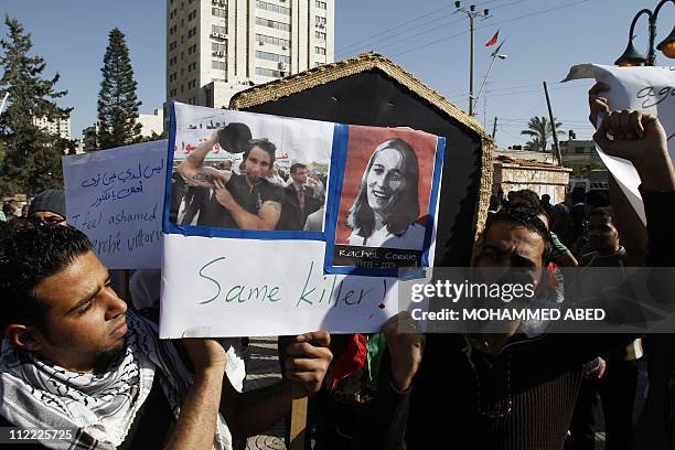 Palestinians carry a placard and a simbolic coffin during a ceremony to mourn and denounce the kidnapping and killing of Italian activist Vittorio...