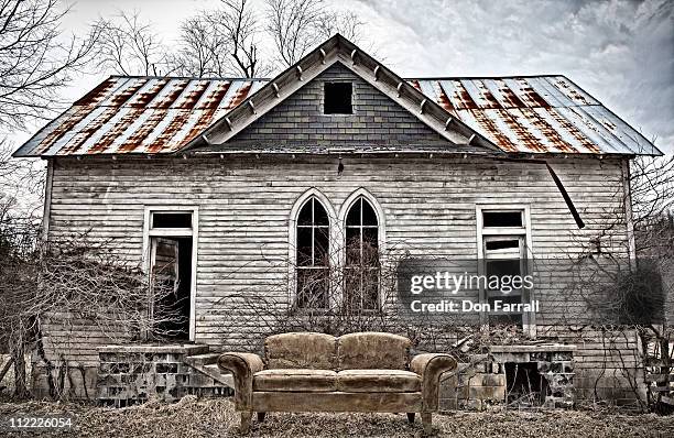 gothic building with old couch - american gothic stock-fotos und bilder