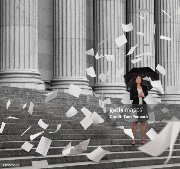 mixed race businesswoman on steps with swirling papers - government policy stock pictures, royalty-free photos & images