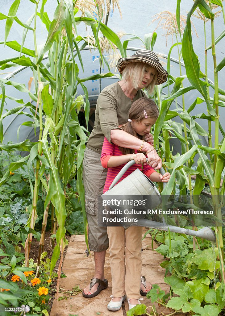 Grandmother educating granddaughter on contributing back to the earth