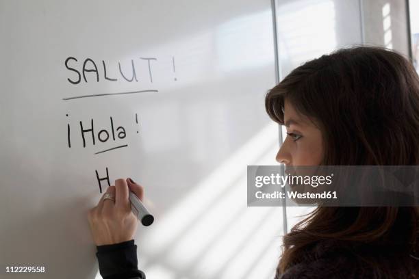 germany, leipzig, young woman writing on drawing board - cultura spagnola foto e immagini stock