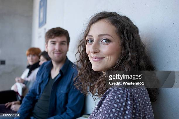 germany, leipzig, man and women smiling, students in background - student stock-fotos und bilder
