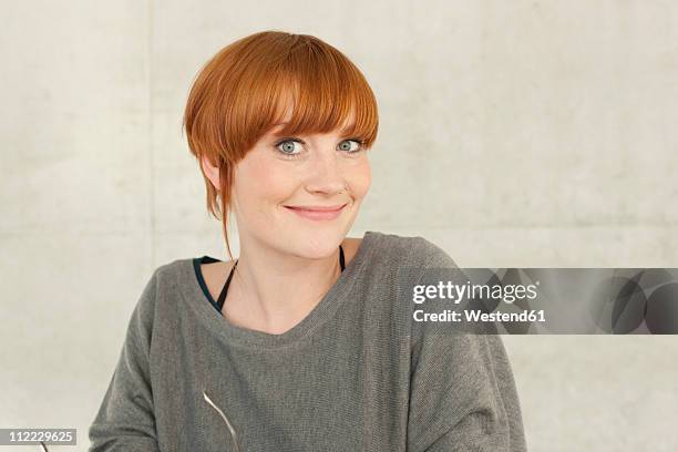 germany, leipzig, young woman standing, smiling, portrait - short 個照片及圖片檔