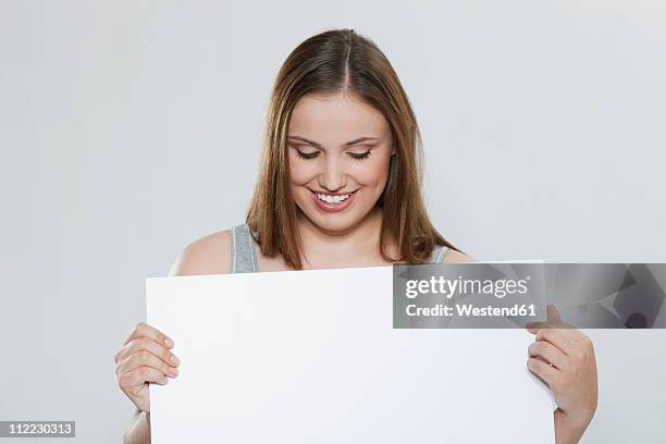 young woman with blank board - person holding blank sign stock-fotos und bilder