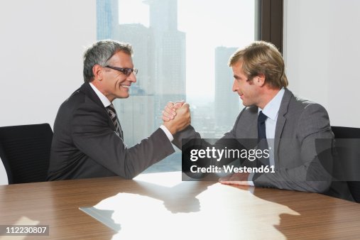 Germany, Frankfurt, Businessmen doing arm wrestling Germany, Frankfurt, Businessmen doing arm wrestling