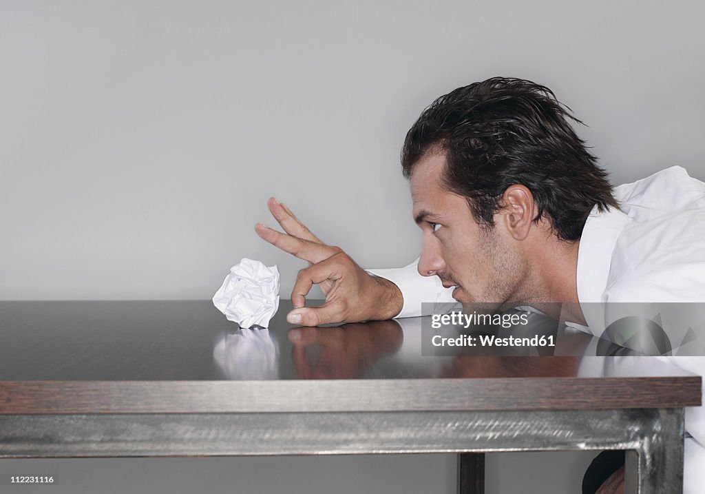 Business man tossing crumpled paper ball