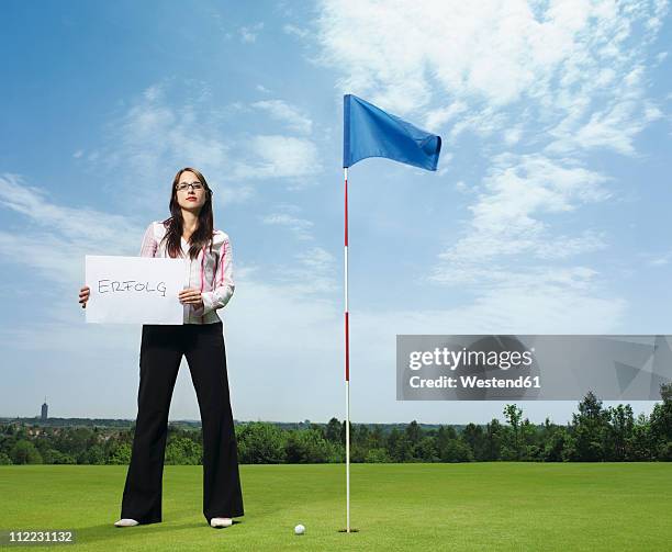 germany, young woman with placard in golf course - golf flag stock pictures, royalty-free photos & images