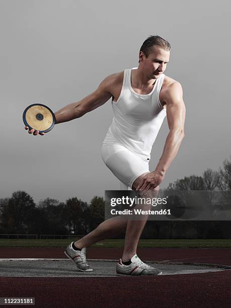 germany, augsburg, young man holding discus - discus stock-fotos und bilder