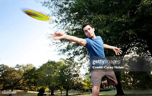 closeup of a man making a backhanded drive playing disc golf. (motion blur) - frisbee fotografías e imágenes de stock