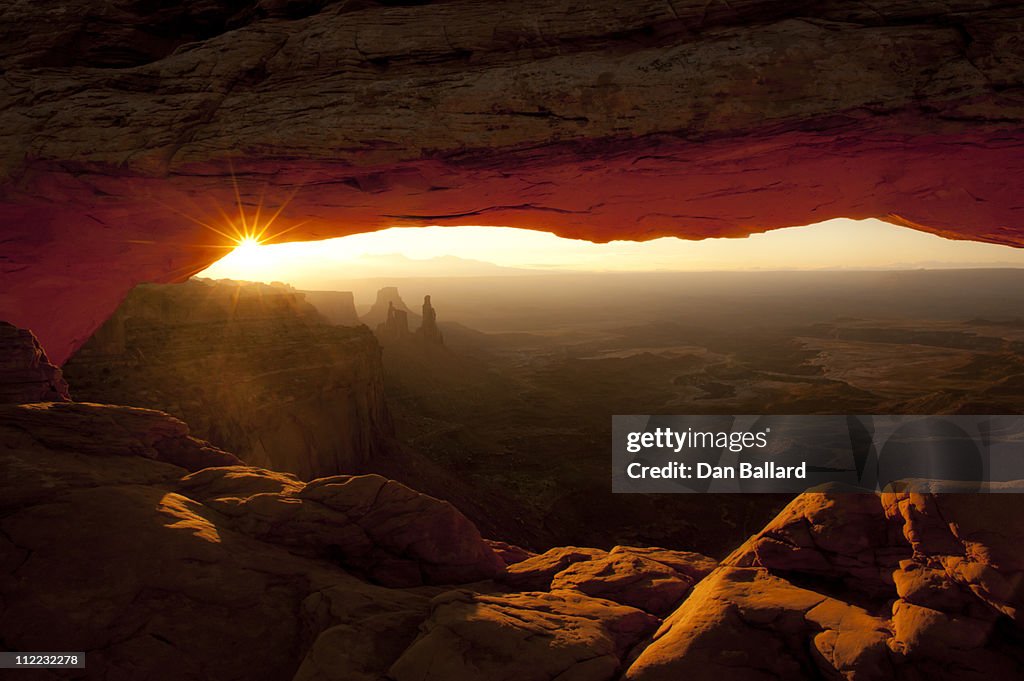 Rock arch with sun and canyon.   Canyonlands National Park, Moab, Utah.