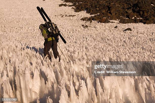 a man ski mountaineering through penitentes on volcan san jose in the andes mountains of chile - penitentes stockfoto's en -beelden