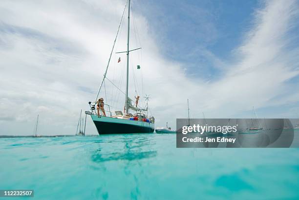 a family anchoring in the harbor after a day sail in georgetown, exumas - georgetown bahama's stockfoto's en -beelden