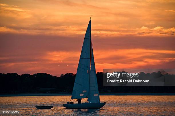 a sailboat at sunset on hilton head island, south carolina. - hilton head photos et images de collection