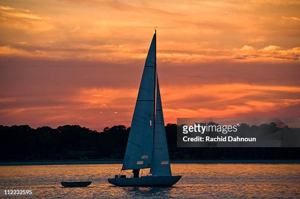 a sailboat at sunset on hilton head island, south carolina. - hilton head stock pictures, royalty-free photos & images